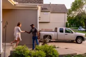 Last mile delivery professional greets a customer at her home.