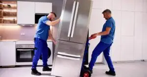 Two men moving a refrigerator and providing white glove delivery service.