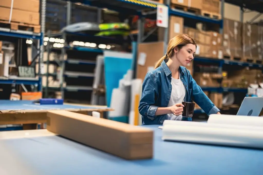 Woman in warehouse evaluating delivery options