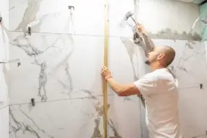 Contractor installing tile in a shower